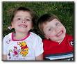 Happyness - Two small children laughing happily in grass.