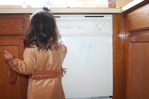 Lydia Drawing on the Diswasher - Lydia is wearing her Pocahontas costume and drawing/coloring on the dishwasher in the kitchen.  She's having fun and wouldn't share the crayons with her sister, which is why she isn't in the picture.