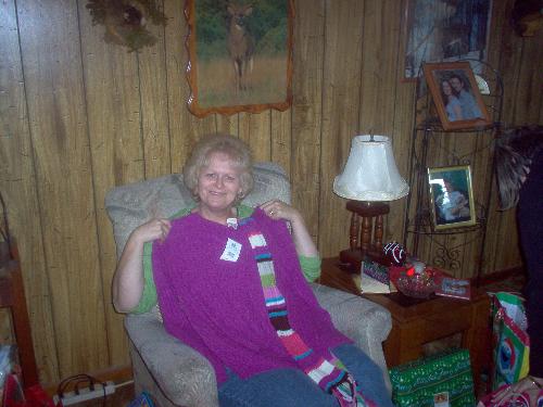 My mom - My mom at her house, she is holding up one of her Christmas presents.