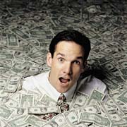 Drowned in dollars - A picture of a man being swallowed up by dollar bills