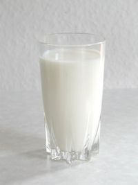 Glass of milk - Milk is an emulsion of butterfat globules within a water-based fluid. Each fat globule is surrounded by a membrane consisting of phospholipids and proteins; these emulsifiers keep the individual globules from joining together into noticeable grains of butterfat and also protect the globules from the fat-digesting activity of enzymes found in the fluid portion of the milk.