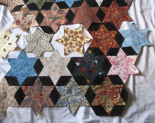 Hand Pieced Star Quilt - I have been making this quilt for quite a while now - can you guess why????? Yes its all hand stitched with tiny little stitches. Hmm I often ask myself why I do it! For non quilters out there - it all starts with a diamond shape (each one is 2.5 inches long) which I print up a page at a time - cut them out, pin onto the fabric and cut around it leaving a small amount for turning. I then tack the seam allowance down, being careful to keep the points sharp. The final step is to stitch them together. I average about 25 stitches each side. That will give you an idea of why its taking a long time :-) The satisfaction is in making the stitches as small and as neat as possible.  I love the look of this quilt - what do you think?