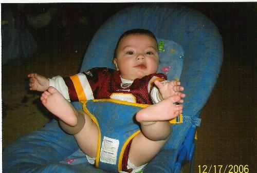 My little redskins fan! - He's learning how to raise his legs up and hold his own feet. =-) Such a BIG MAN!