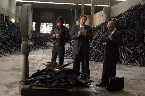 Lord of War - In the 80s in Little Odessa, the Ukrainian immigrant Yuri Orlov (Nicolas Cage) decides to change his economical life and becomes an arm dealer with his brother Vitaly Orlov (Jared Leto). His business of gunrunner supplying illegal weapons in disturbed areas of the planet increases with the end of the Cold War, and Yuri bribes a Russian general to sell most of his arsenal. Meanwhile, he becomes a millionaire and uses his money to seduce the beautiful Ava Fontaine (Bridget Moynahan) and they get married, having a son. The detective Jack Valentine (Ethan Hawke) chases Yuri trying to put him in jail, but in the end he understands that Yuri is a necessary evil for the interest of his nation. Source: http://www.imdb.com/title/tt0399295/plotsummary
