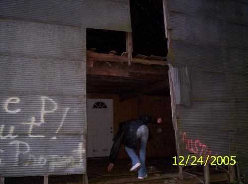 Orb of Austin - This is a picture of an abandon barn. And that butt in the pic is my friend Amber...And the white circle next ot her is an orb, the spirit of a 7 year old who died here back in the 90's. Austin father owned the barn, and eventully used it as storage and built a bigger barn, well it had a second story and that is where Austin loved to go and play. Well the floors were starting to rot out and it was really going downhill. But Austin loved to play there, well his dad let him go and play one day, and he never came back when he was supposed to, being a concerned father, his father went to the barn and found that Austin had fallen from the 2nd story to the 1st through the floor, he didnt know how it happened, but Austin did die in his fathers arms, and he later after the funeral, he sprayed painted austins name on the front and walked away and never came back he put the property up forsale and has been ever since