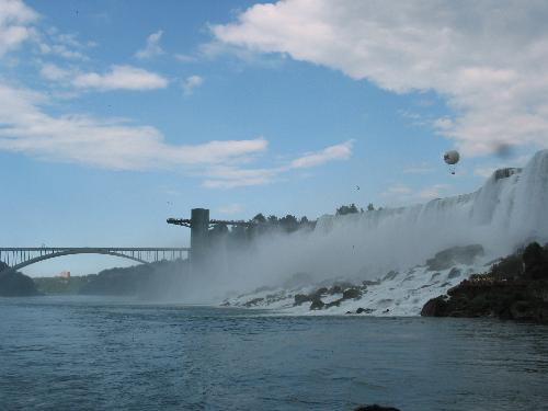 niagara falls - Niagara Falls is a set of massive waterfalls located on the Niagara River in eastern North America, on the border between the United States and Canada. Niagara Falls (French: les Chutes du Niagara) comprises three separate waterfalls: the Horseshoe Falls (sometimes called the Canadian Falls), the American Falls, and the smaller, adjacent Bridal Veil Falls. While not exceptionally high, Niagara Falls is very wide. With more than 6 million cubic feet (168,000 m³) of water falling over the crestline every minute[1] in high flow, and almost 4 million cubic feet (110,000 m³) on average, it is the most powerful waterfall in North America.[2] Niagara Falls is located about twenty minutes away from the U.S. city of Buffalo and about 90 minutes from the Canadian city of Toronto.  Some sources erroneously quote that Niagara Falls has an average flow of about 12 million cubic feet per minute (200,000 cu ft/s) or even slightly more. This figure is derived from the average rate of flow (202,000 cu ft/s) of the Niagara River. This volume would pass over the falls if there were no hydroelectric water diversion upstream from the falls; however, water is diverted continuously from Niagara and this figure is approximately three times the actual average flow volume over the falls.  Niagara Falls is renowned for its beauty, and is both a valuable source of hydroelectric power and a challenging project for environmental preservation. A popular tourist site for over a century, the natural wonder is shared between the twin cities of Niagara Falls, Ontario and Niagara Falls, New York.