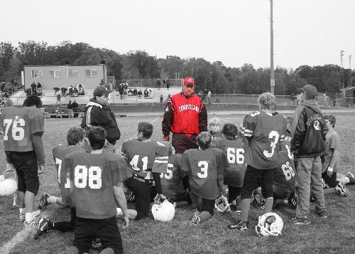 A football Coach talking to his team - By using Photoshop Elements I was ableto creat this black and white photo with the Coach, Focal Point, in color.  Very interesting effect and I have gotten very positive comments from this type of photo.  This was created by using tye layers tool.  You creat a greyscale photo by removing the color from the picture.  You then copy the whole photo and then undo the removing color and paste the copied photo over the color photo.  Using the ereaser tool remove the greyscale layer from the part you want to show through in color.  Then you save it as a new file.