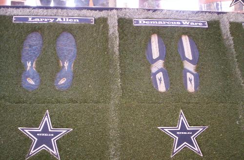 Shoe Sizes of Dallas Cowboys - I was at the Country Fair of 2006 at the Cowboys Stadium in Irving and they had a big semi truck with all kinds of cool Cowboys stuff inside, this shows the bottom of the soles of some of their shoes, I put my foot in the one on the left and my foot is HALF the size of that one.