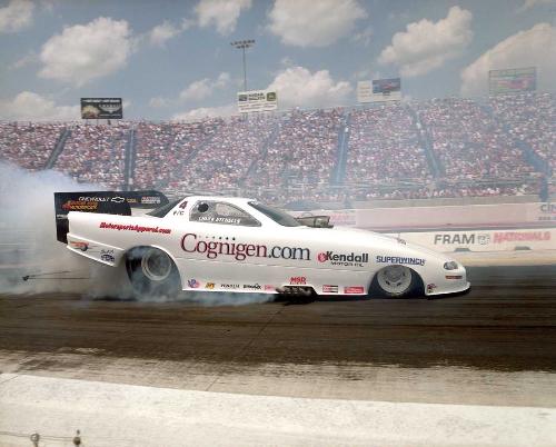 Cognigen Funny Car - A few years ago, I sponsored this nitro-fueled 'funny car' drag racing car in the NHRA (National Hot Rod Association) finals at Indianapolis Indiana.  The owner of the car did not have a regular sponsor, so I got a one-time bargain price of USD $50,000.  I made the best of the opportunity by hiring some models (dressed in a minimal amount of clothing) to hand out our company brochures with an autographed photo of our driver on one side of the brochure.  The owner/driver of the car was Chuck Etchells. I learned much, and had a lot of fun during that three day racing event.  Racing a top funny car is an expensive proposition -- for example, they go though an engine block, on average, once for each eight quarter mile trips down the track. Maintaining a crew of 10 or more experienced mechanics; transportation; hotel, fuel and other expenses drive the cost up to over $2.5 million for one racing season.  We got a real bargain, even though the adventure lost money overall for us.