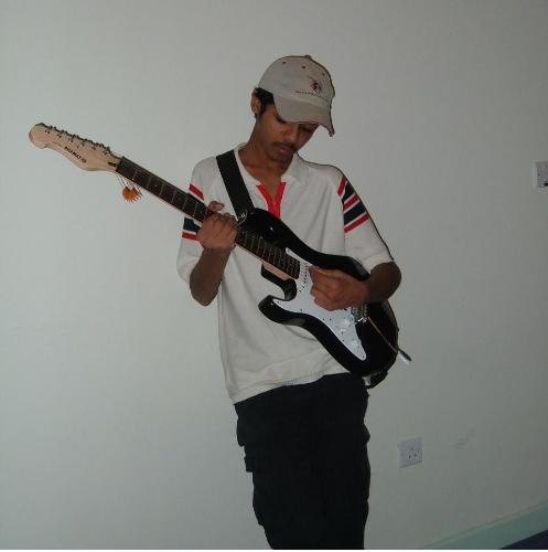 Me posing with guitar - this photo is taken by one of my good friend its a photo of me standing against the wall playin a guitar...